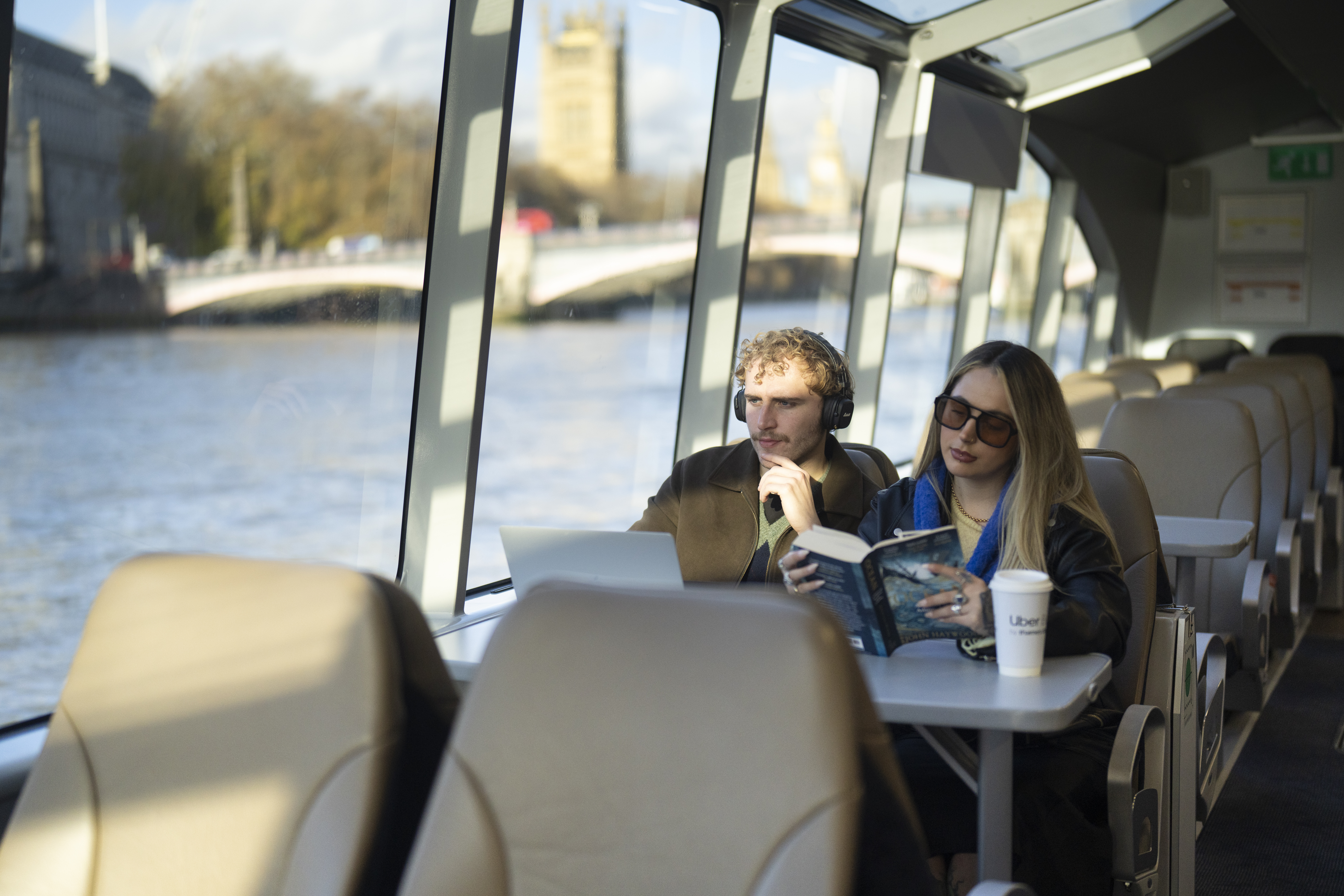 A couple of friends at a table (laptop and reading)