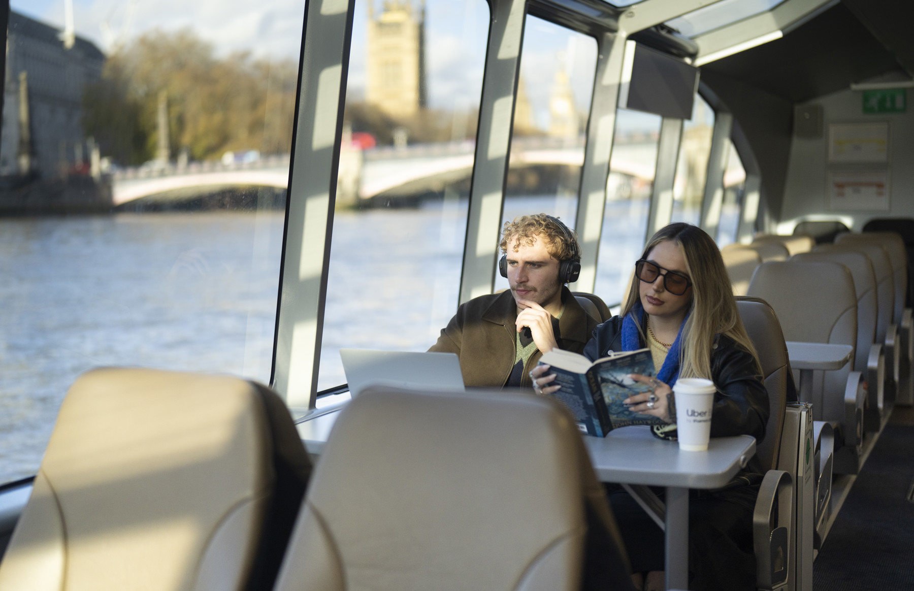 A couple of friends at a table (laptop and reading)